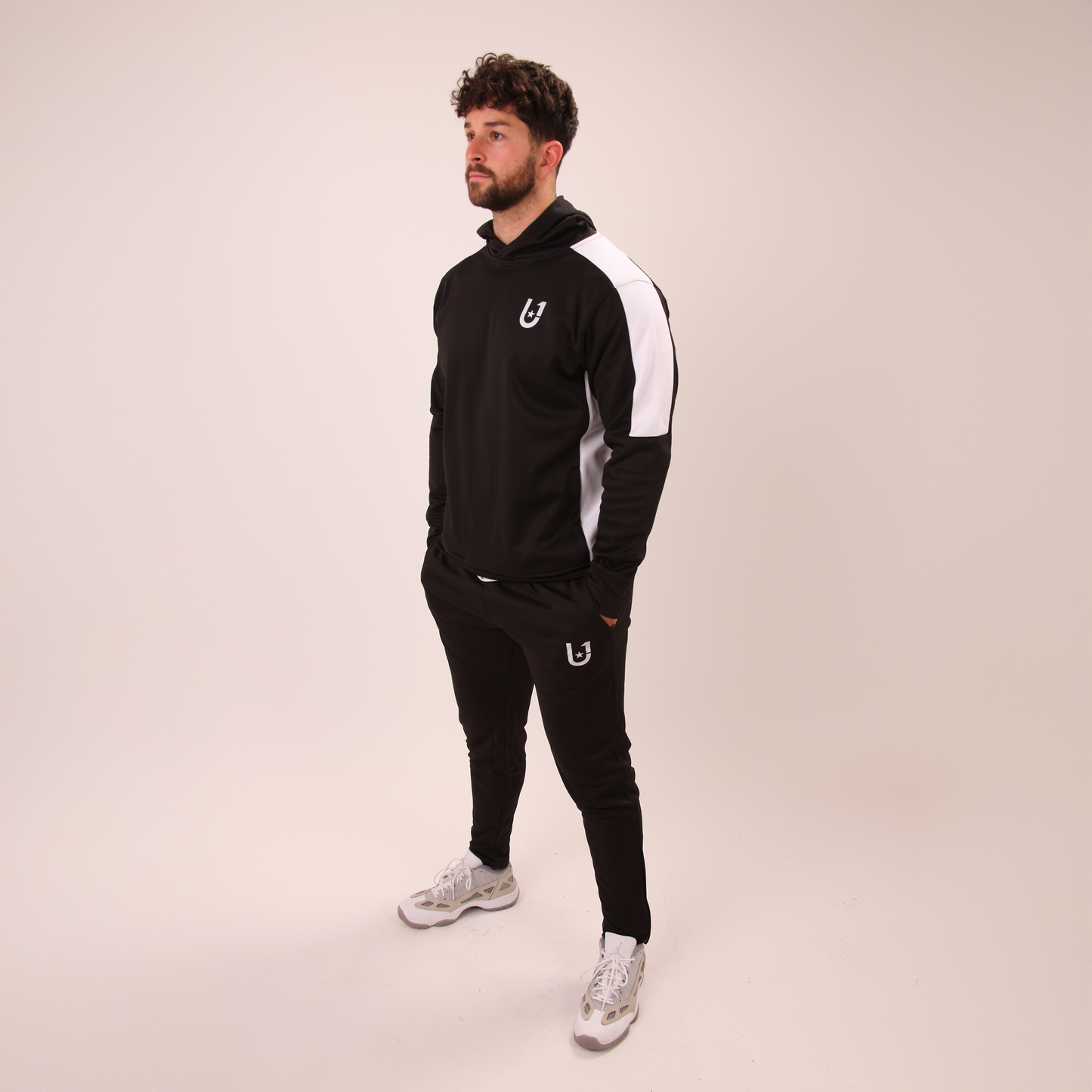 full-length image of UNIFY men's black track pants styled for casual or active looks
