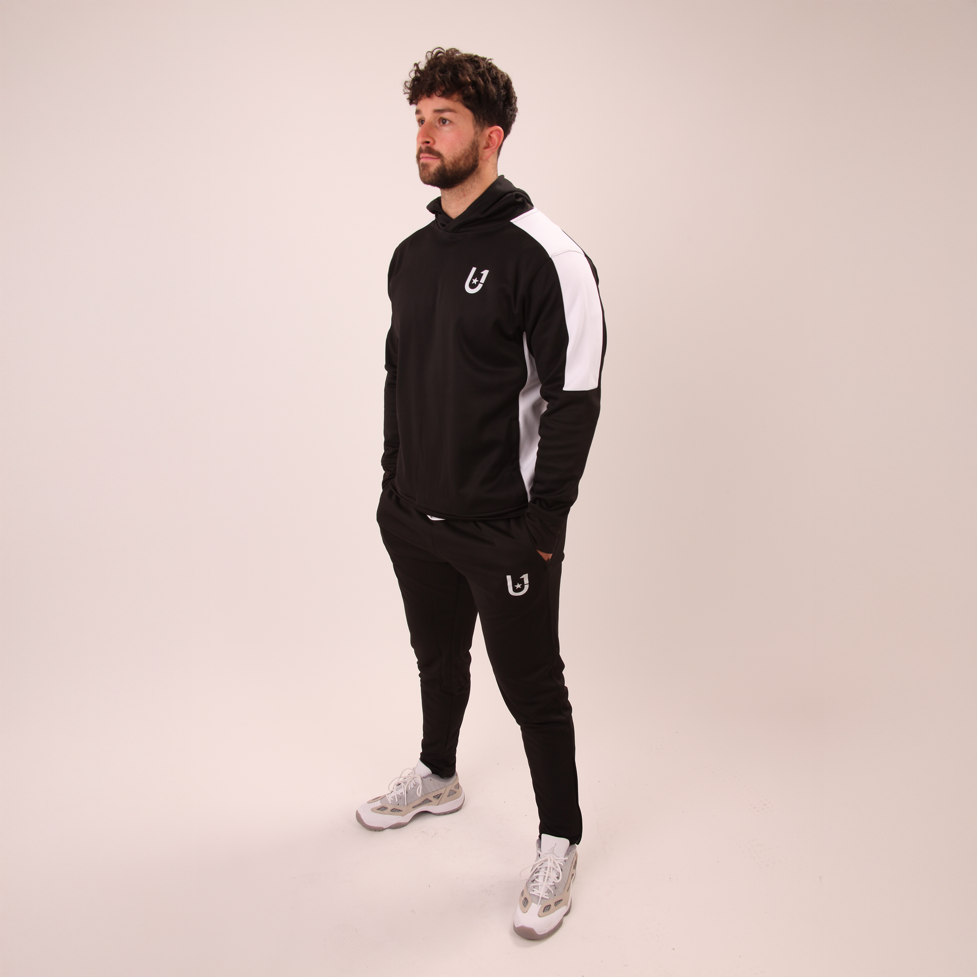 full-length image of UNIFY men's black track pants styled for casual or active looks
