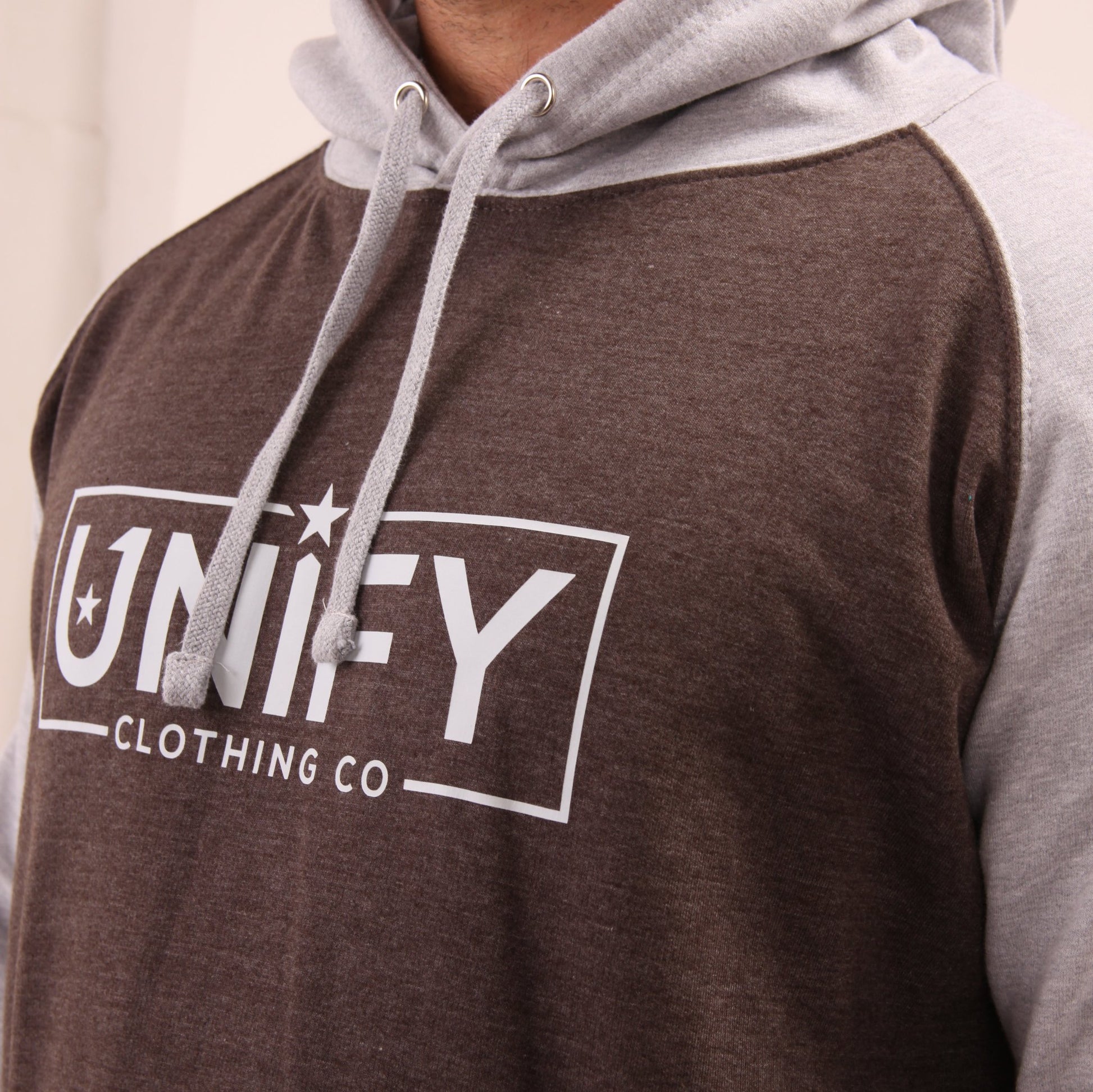 "Fashion-forward and functional, UNIFY's grey hoodie on a model, ideal for any urban adventure."