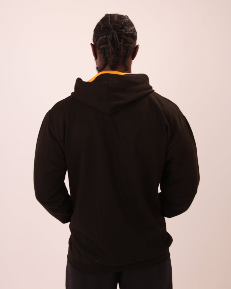 Man wearing a black and yellow UNIFY zip hoodie, ideal for casual wear or light sports activities.