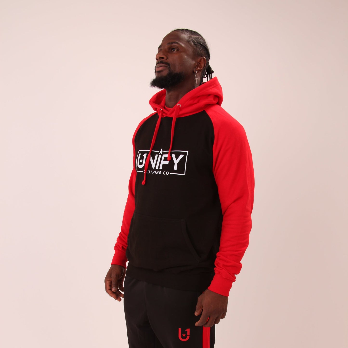 "Man wearing the UNIFY Red/Black Hoodie, showcasing the vibrant red color and detailed branding, ideal for expressive individuals."