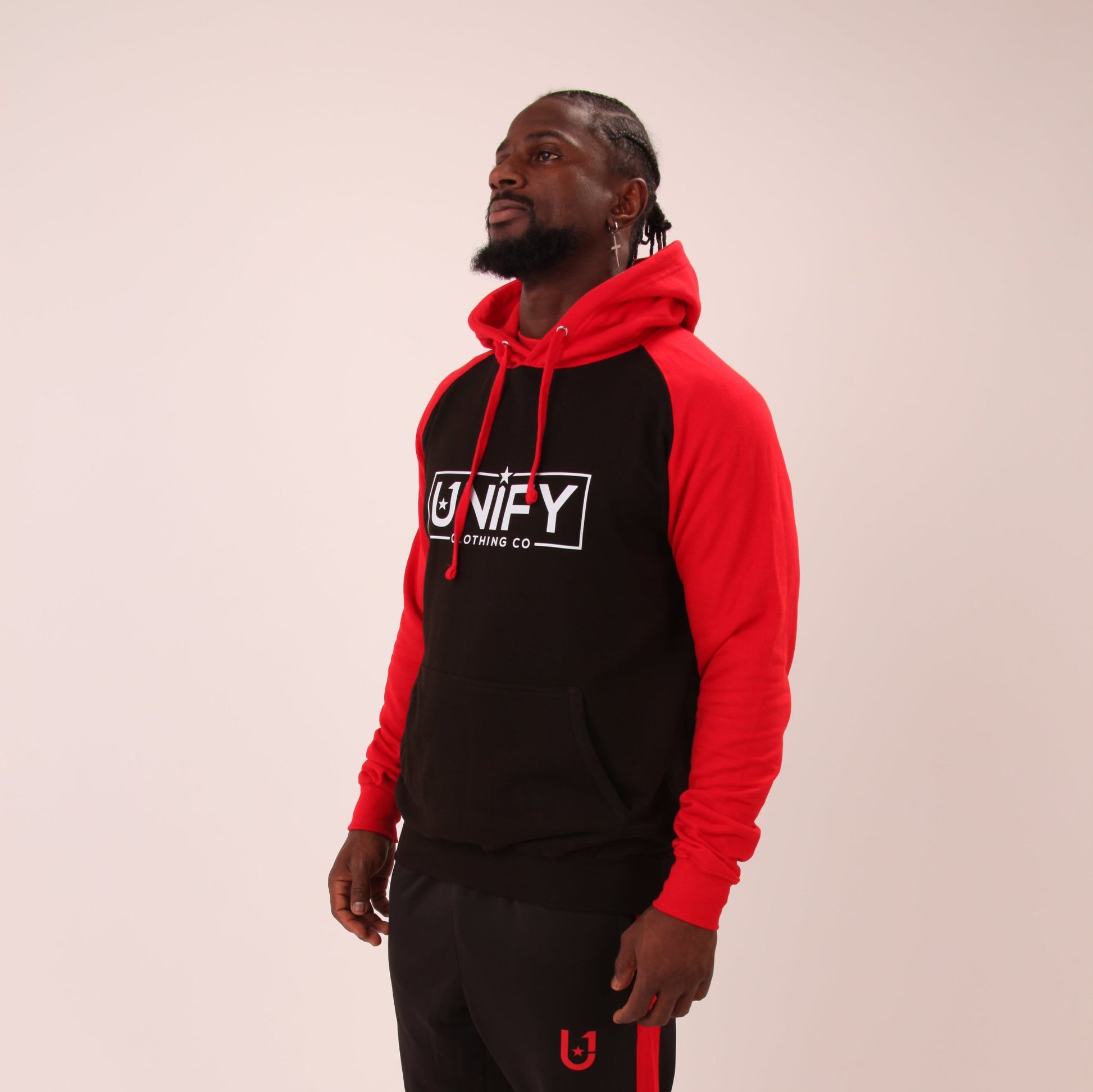 "Man wearing the UNIFY Red/Black Hoodie, showcasing the vibrant red color and detailed branding, ideal for expressive individuals."