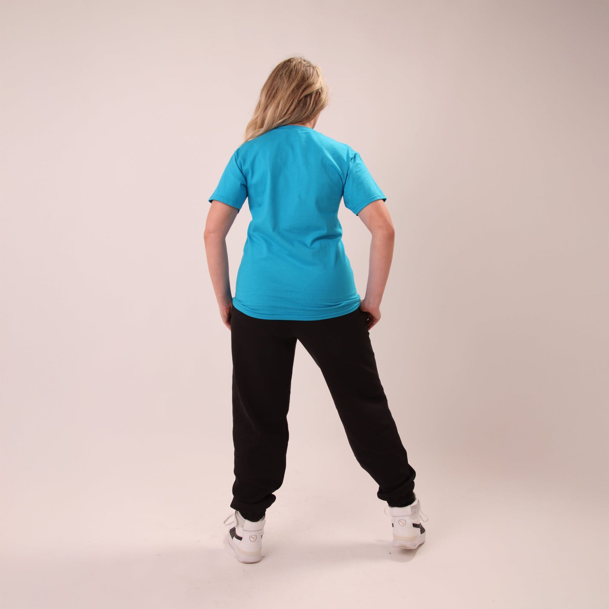 Woman wearing UNIFY relaxed black joggers, ideal for versatile fashion from day to night.