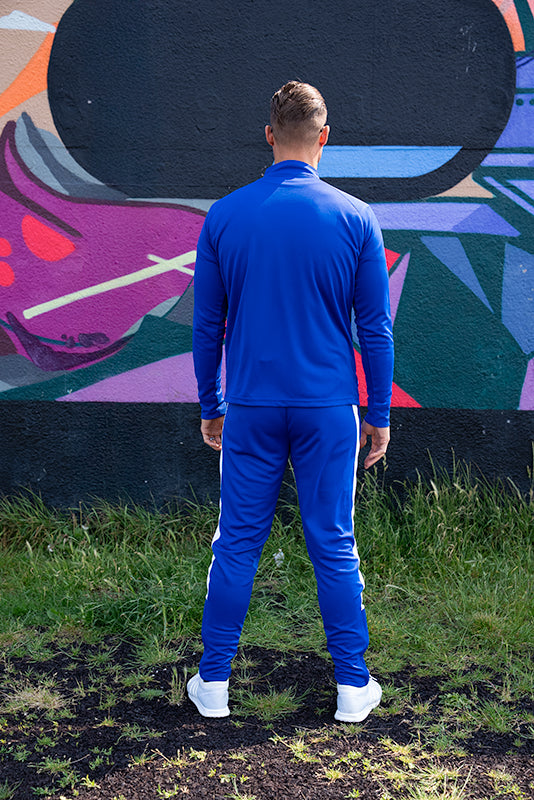 back view of UNIFY crossover track suit in blue and white stripe design