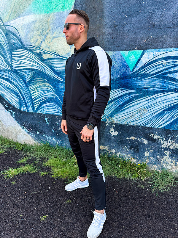 Side profile of UNIFY men's tracksuit in black with white stripes