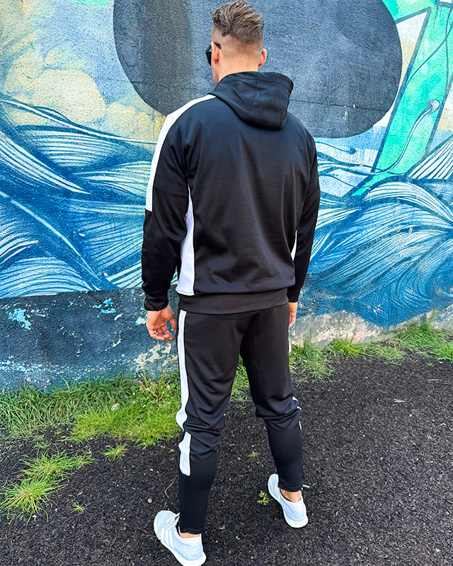 Styled model wearing UNIFY black and white crossover tracksuit