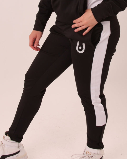 "UNIFY women's track pants in black with white accents, blending fitness wear with contemporary fashion."