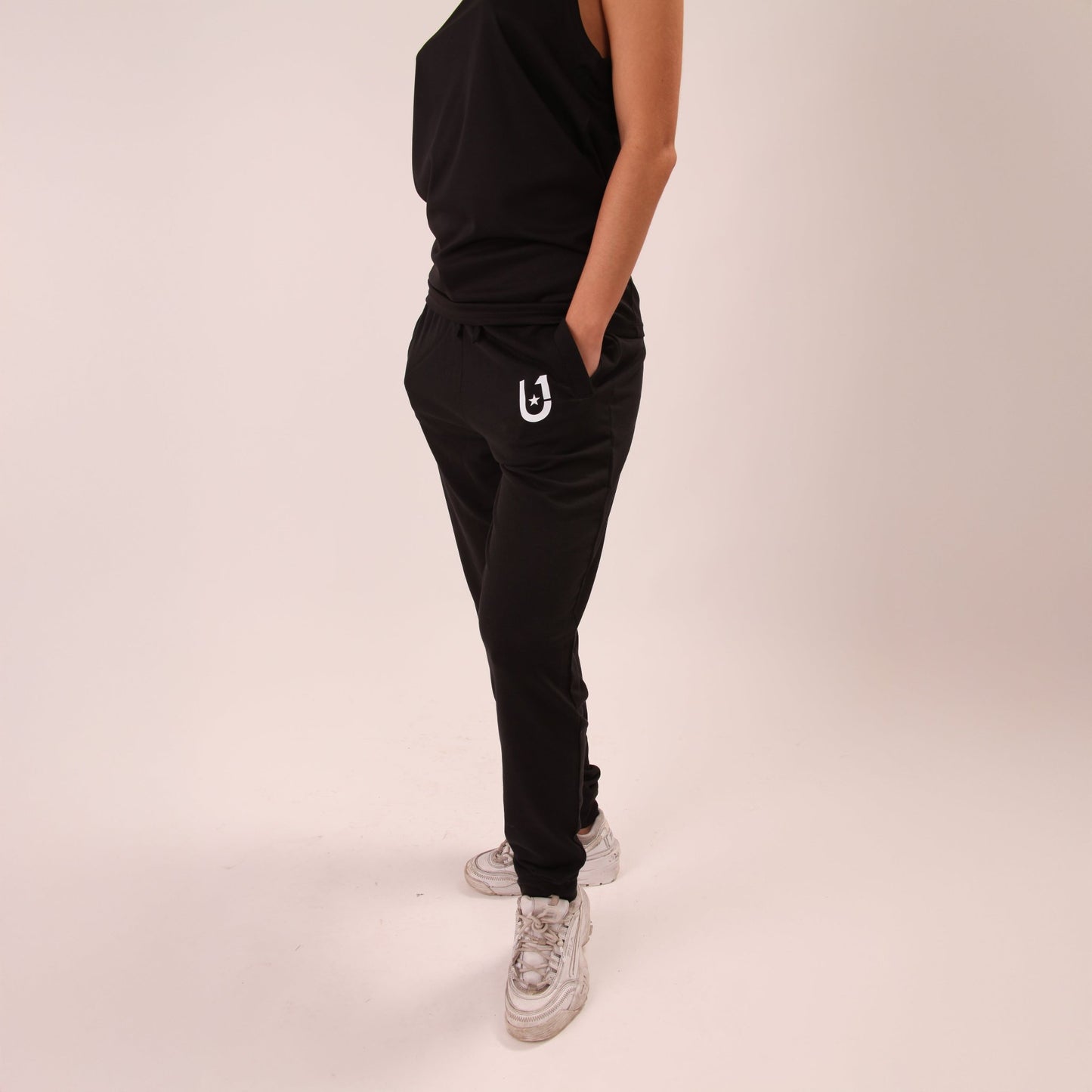Active woman stretching in UNIFY's joggers, designed for optimal comfort and mobility.
