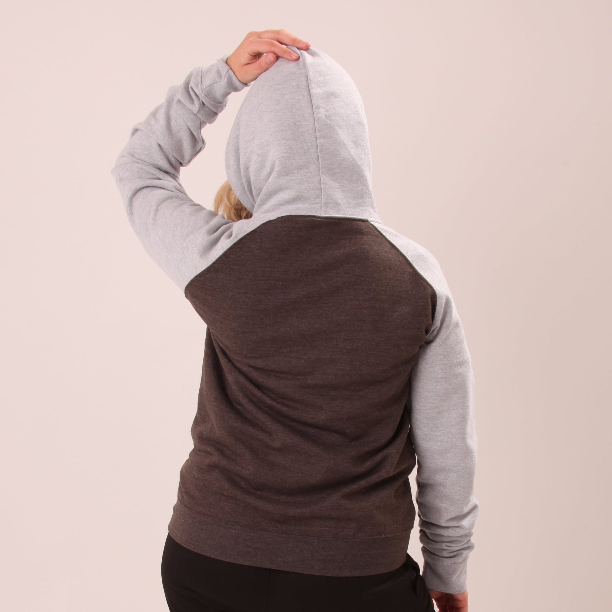 "A woman wearing the UNIFY grey hoodie, perfectly blending comfort with contemporary fashion."