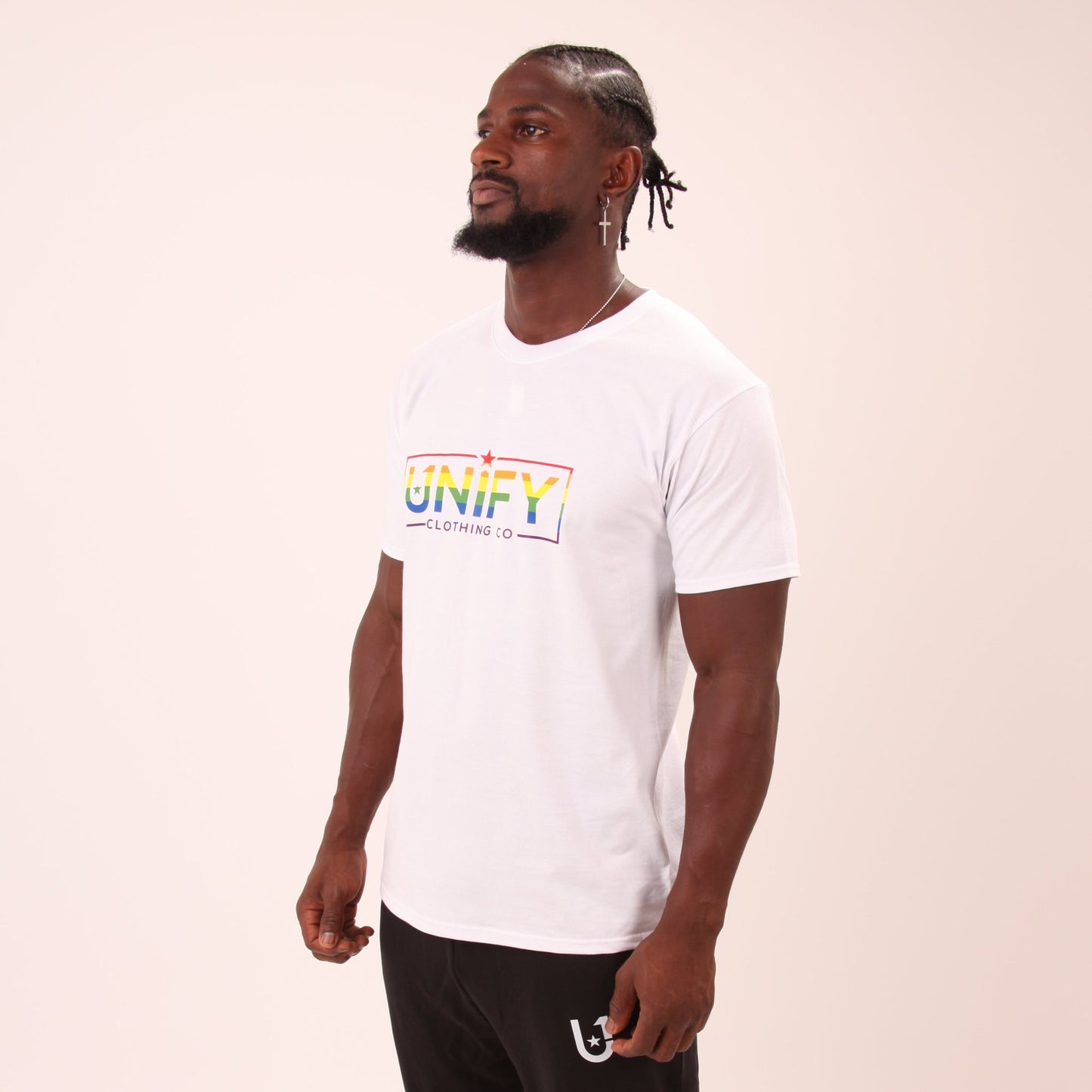 "Man wearing a bold rainbow Pride tee by UNIFY, symbolizing love and equality."
