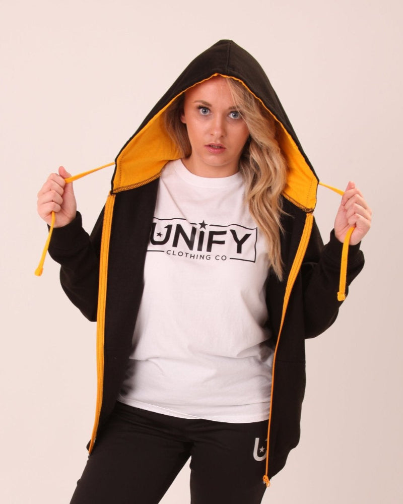 Detailed view of UNIFY's women's black hoodie with yellow accents, emphasizing its stylish and functional design.
