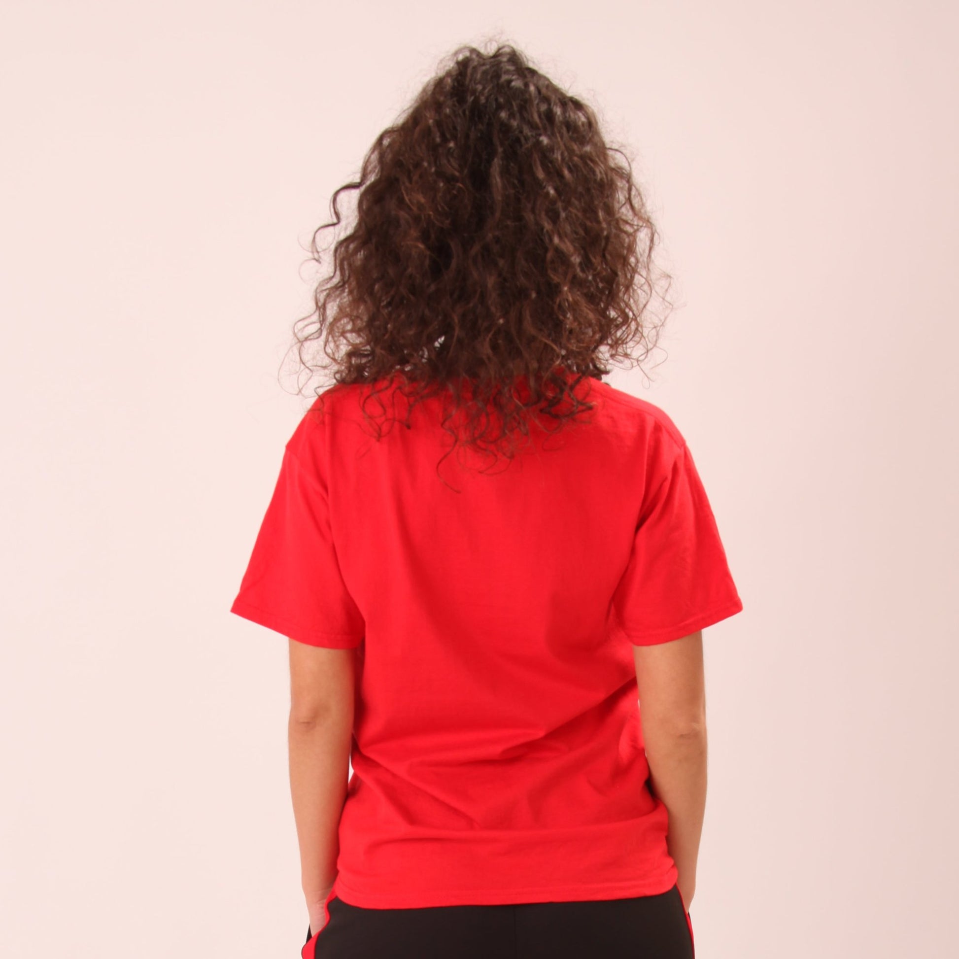 "Woman modelling a classic red tee by UNIFY, highlighting its vibrant hue and comfortable fit."
