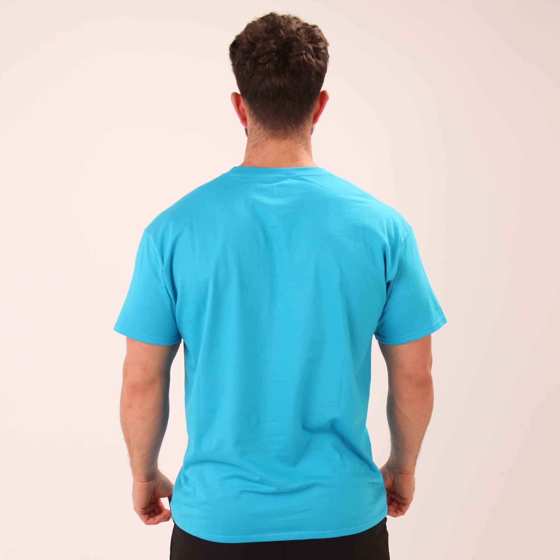 "Lifestyle shot of a man wearing a deep blue cotton tee by UNIFY, ideal for both active and relaxed settings."
