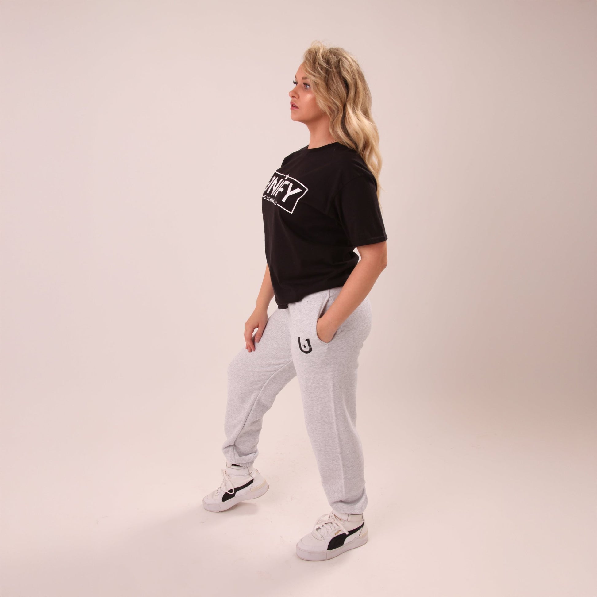 Fashionable woman in UNIFY grey relaxed joggers, ideal for both active and leisure times.
