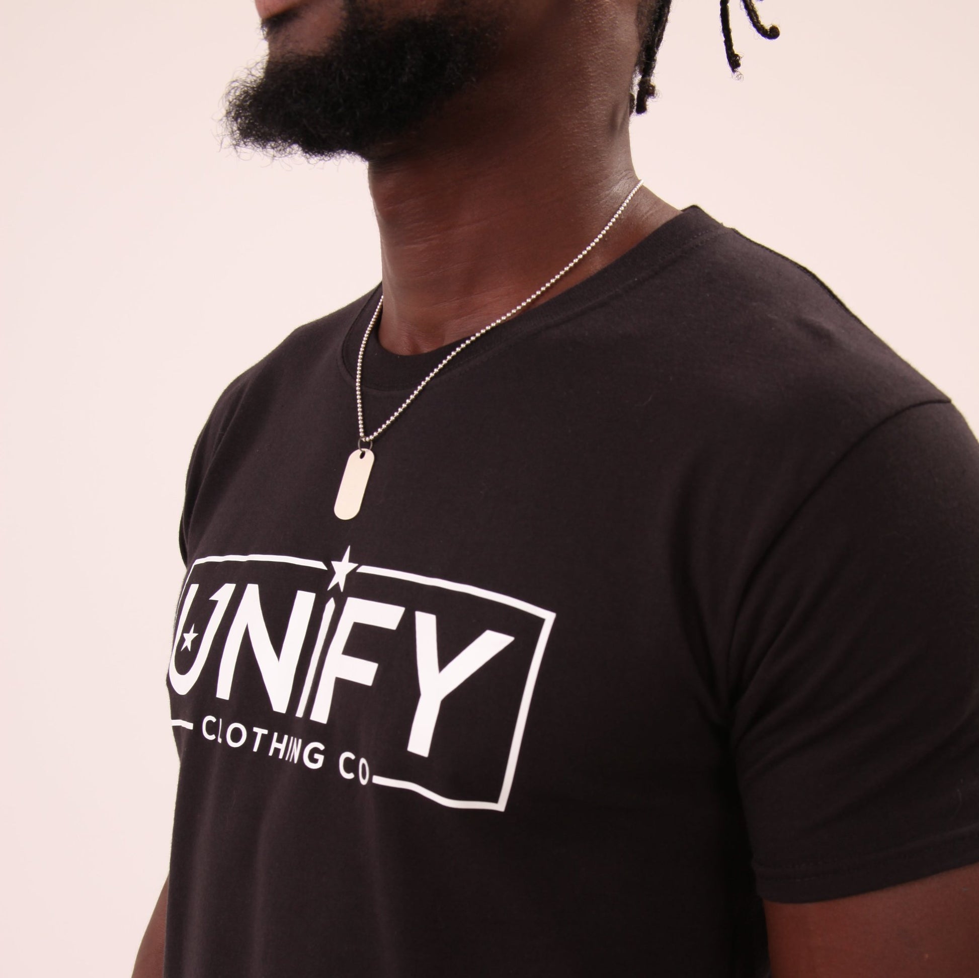 "Stack of UNIFY Black T-Shirts, emphasizing the soft hand feel and sleek design."
