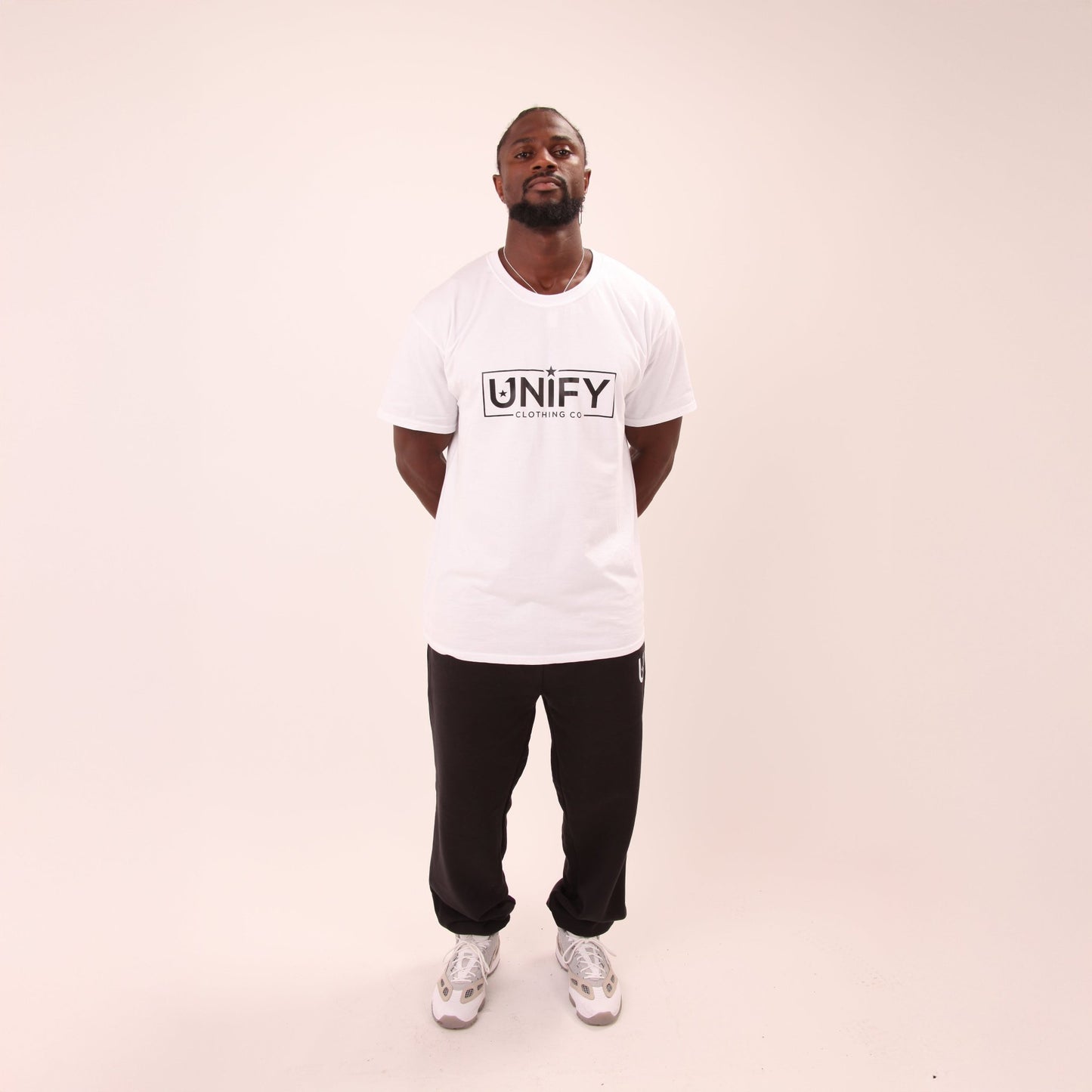 Detail of UNIFY's relaxed fit black joggers, highlighting their roomy design and soft fabric.