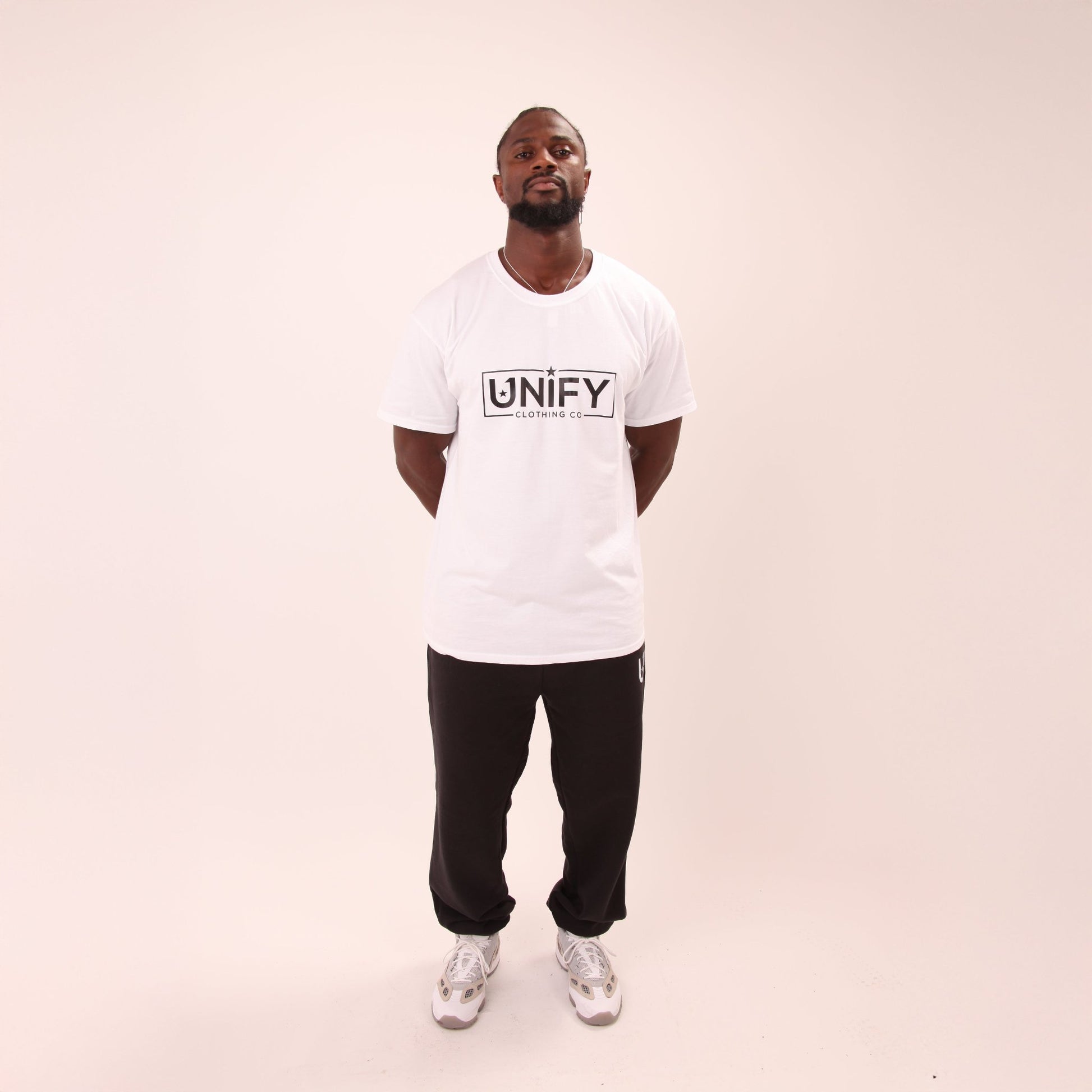 Detail of UNIFY's relaxed fit black joggers, highlighting their roomy design and soft fabric.