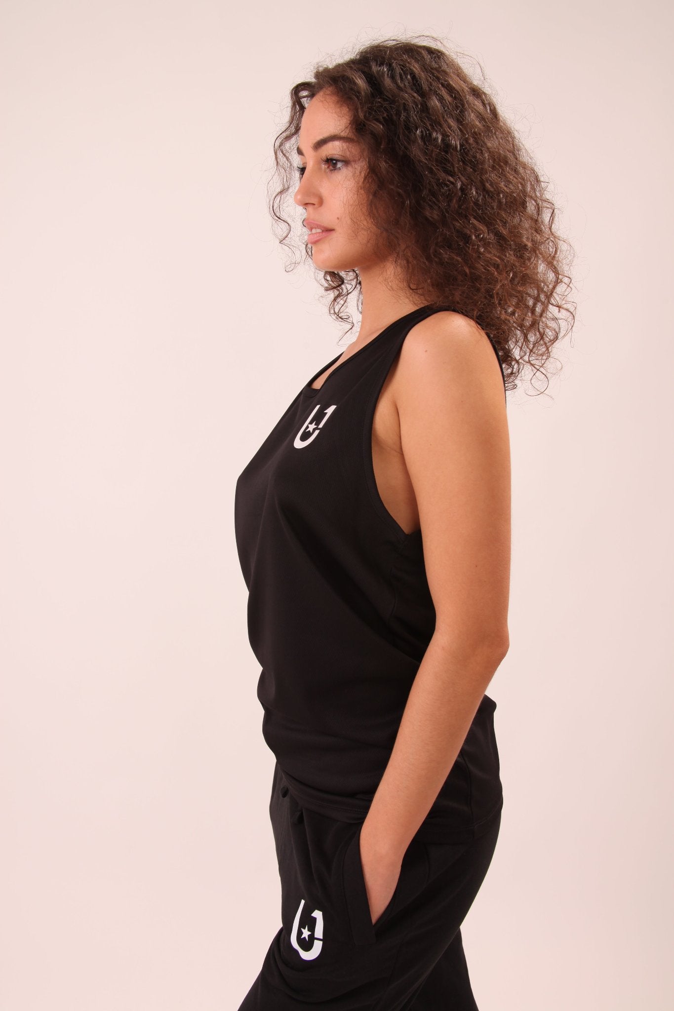 Comfortable and stylish UNIFY black athletic vest for women, tailored for both high-intensity workouts and everyday athleisure.