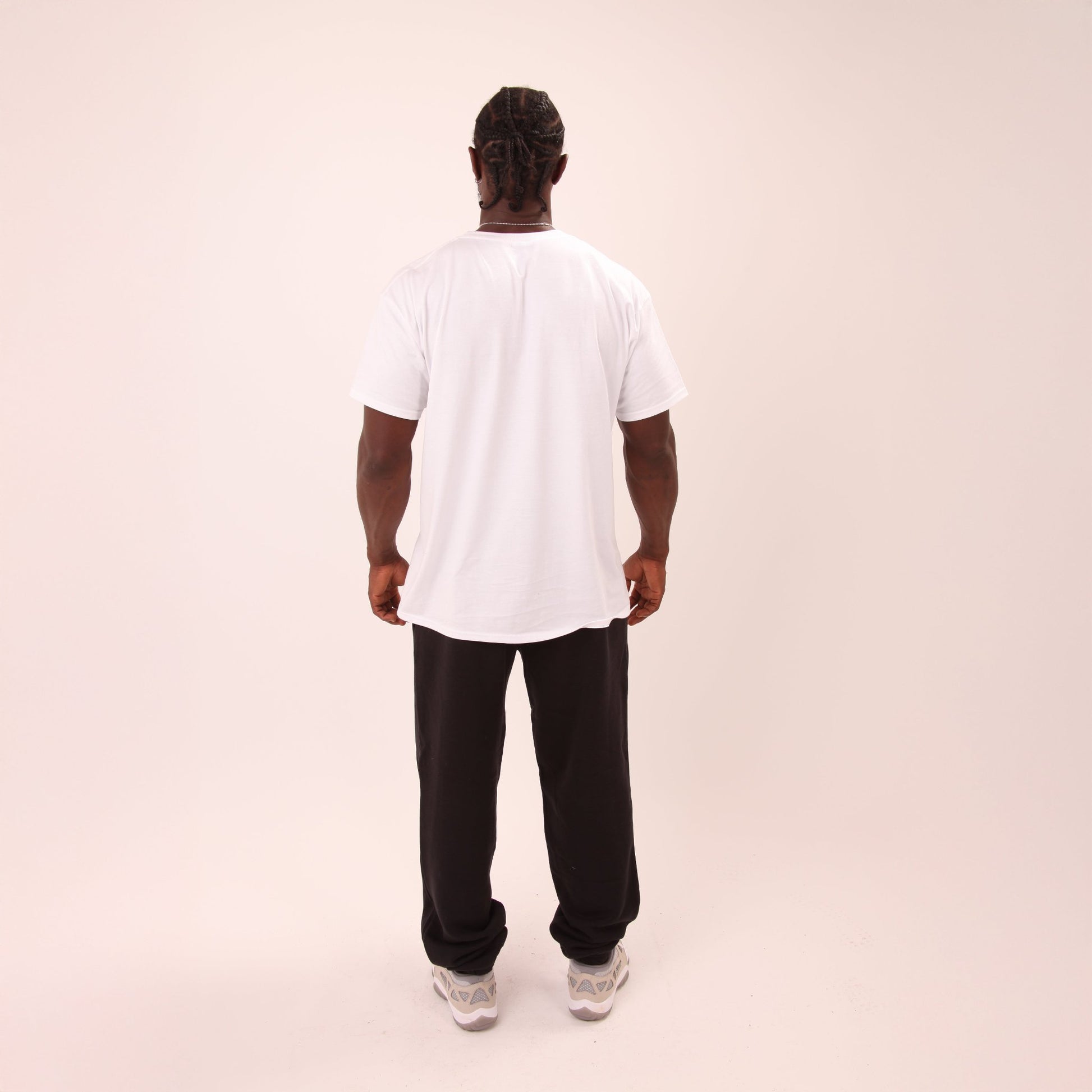 Stylish man lounging in UNIFY black relaxed joggers, ideal for comfort and versatility.