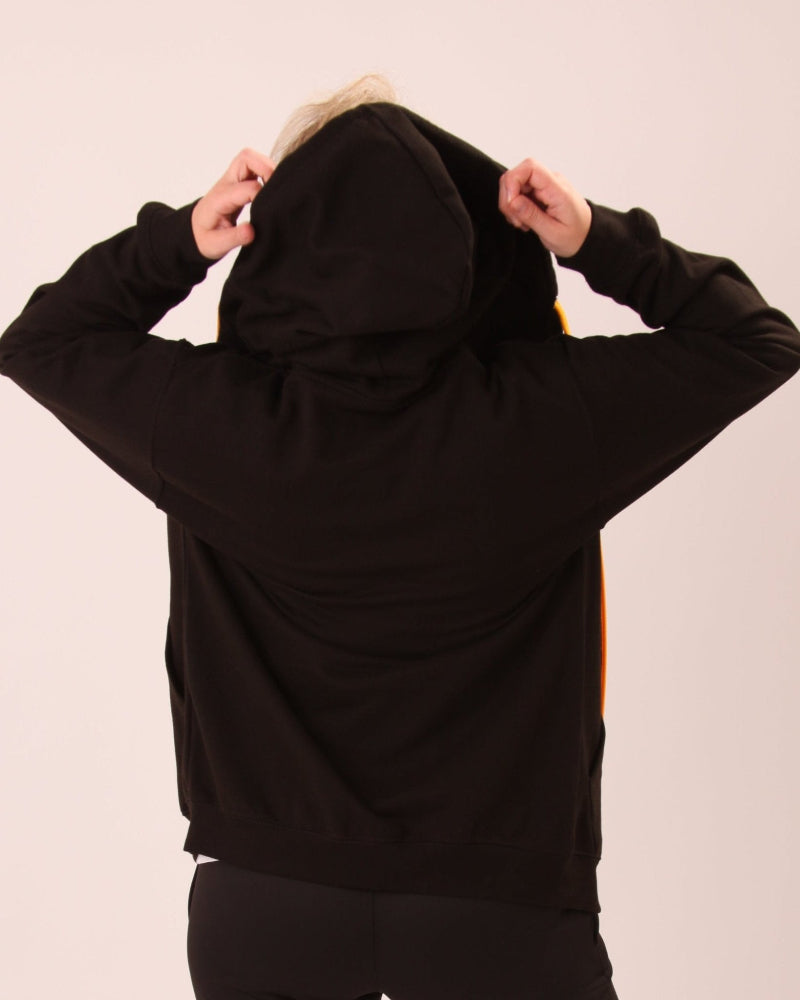 UNIFY's vibrant black and yellow women's hoodie showcased, highlighting its sleek silhouette and bold colours.
