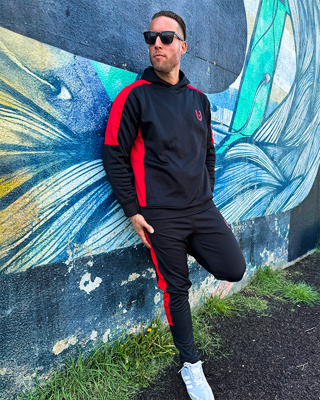 Front view of UNIFY black and red stripe track suit with bold contrast design