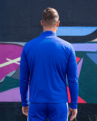 Close-up of zip and collar detail on the UNIFY blue and white track top