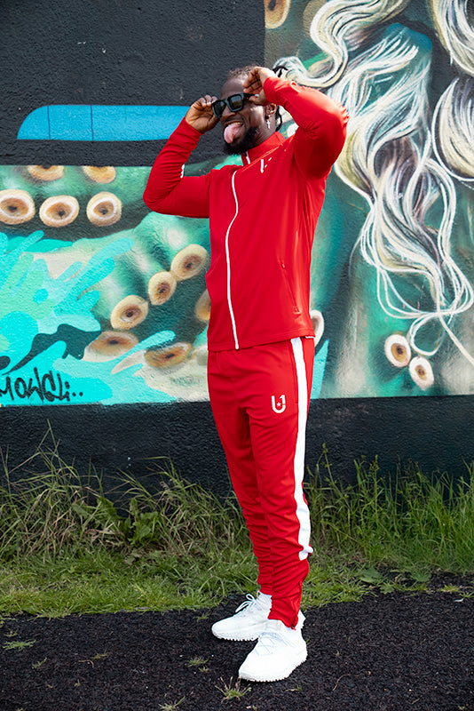 Model wearing UNIFY red and white track top styled for everyday wear