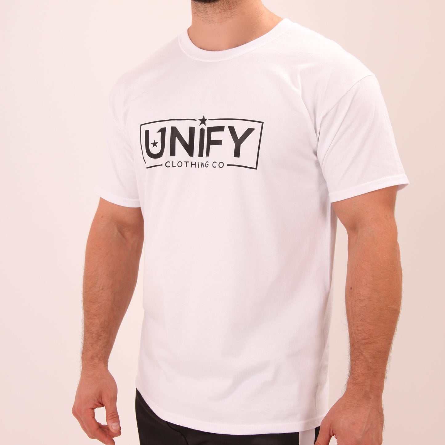 "Stylish man in a classic white tee by UNIFY, ideal for both casual and formal layering."
