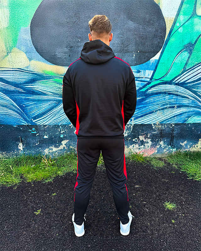 back angle of black and red stripe track suit showcasing athletic fit