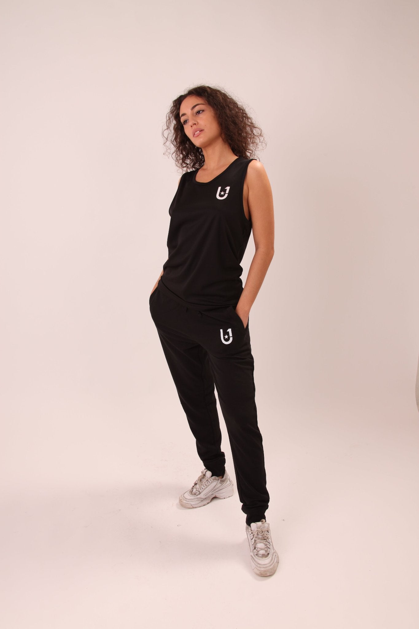 Sleek black sports vest by UNIFY, featuring lightweight, breathable fabric for women, ideal for gym and casual wear.