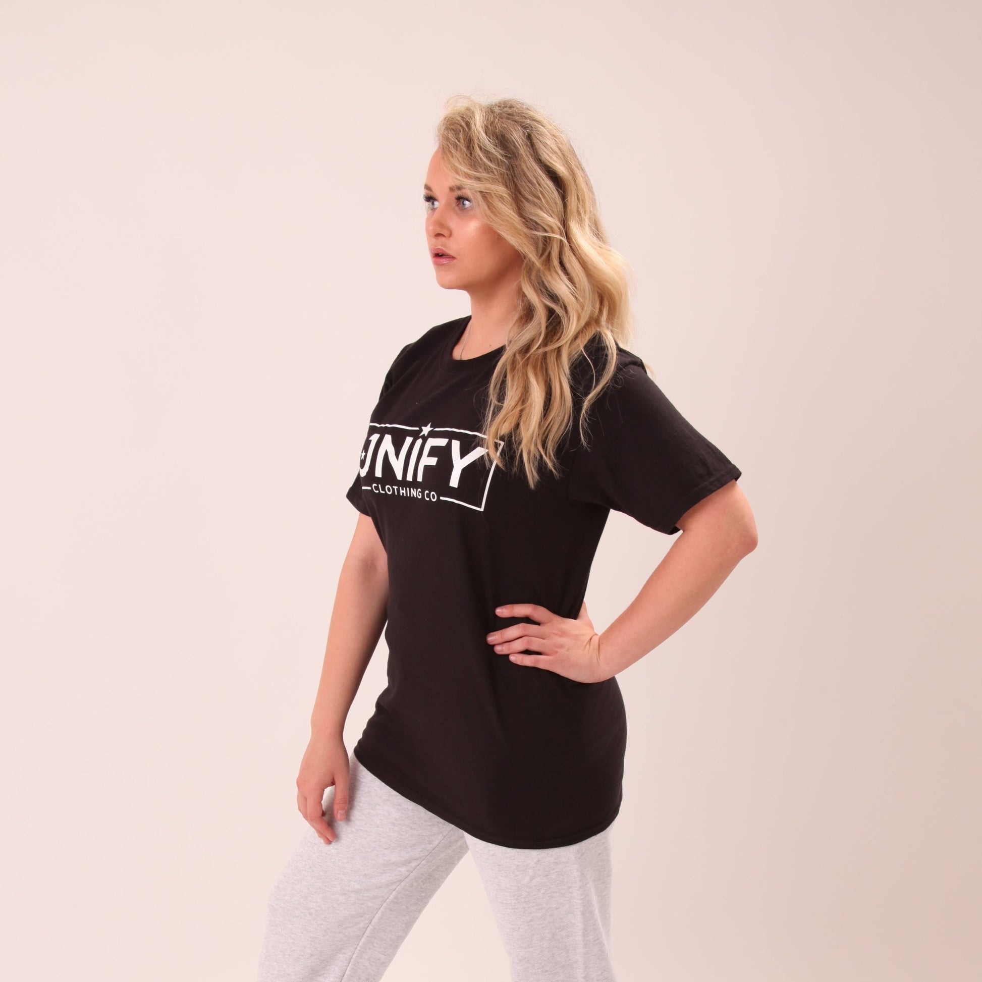 "Stylish women's black tee by UNIFY, paired with jeans for a timeless look."
