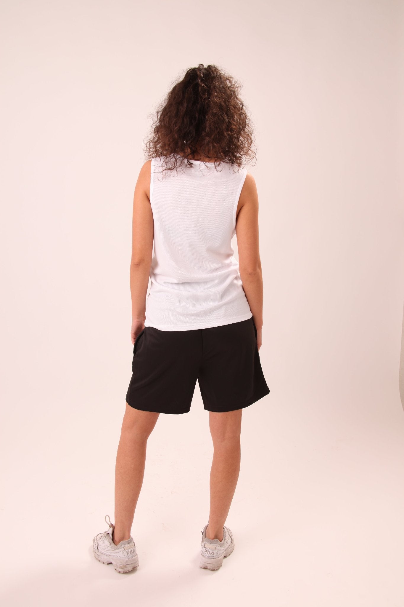 UNIFY Performance White Tank Top for ladies, designed for optimal breathability and style in active settings