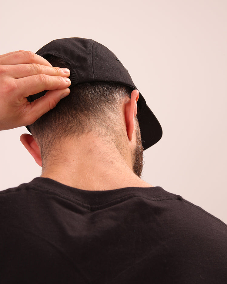 Close-up of UNIFY black streetwear cap, highlighting its sleek design and durable material.