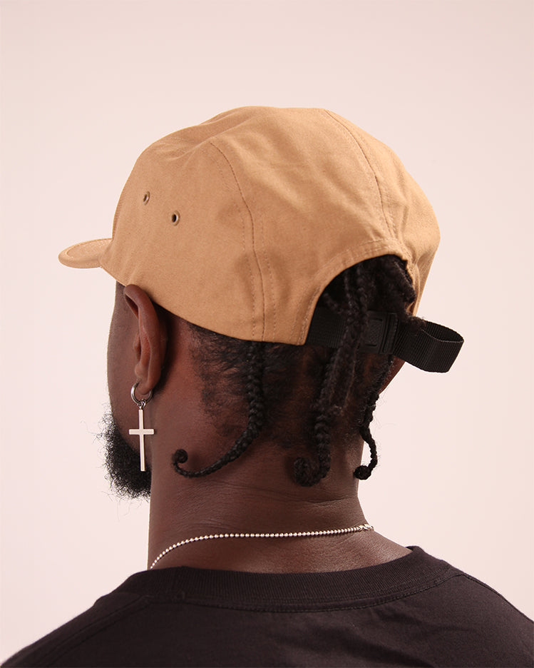 A man sporting UNIFY's beige 5-panel cap, perfect for a polished, street-smart look.