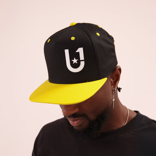 "Cool yellow baseball cap by UNIFY, designed to provide comfort and UV protection on sunny days."
