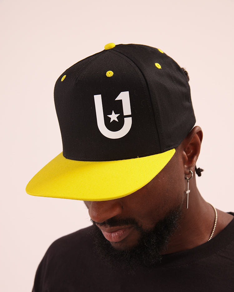Cool yellow baseball cap by UNIFY, designed to provide comfort and UV protection on sunny days.